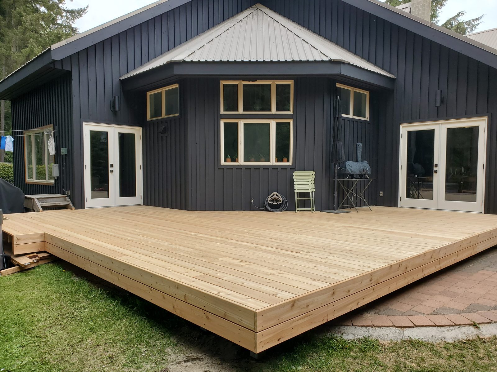 New cedar deck built against a dark-clad Whistler home
